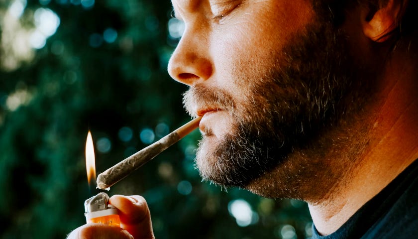 A man is lighting up a joint.