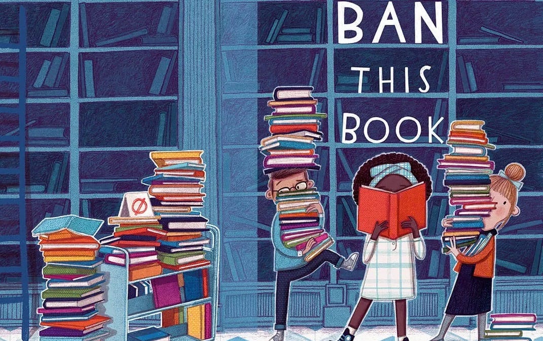 Cover illustration for 'Ban This Book,' a cartoony picture of a Black middle-school girl who's face is hidden by the book she's reading, flanked by a white boy and girl who are carrying huge stacks of books in front of a mostly-empty library bookshelf. Tag line above title: 'You're never too young to fight censorship'