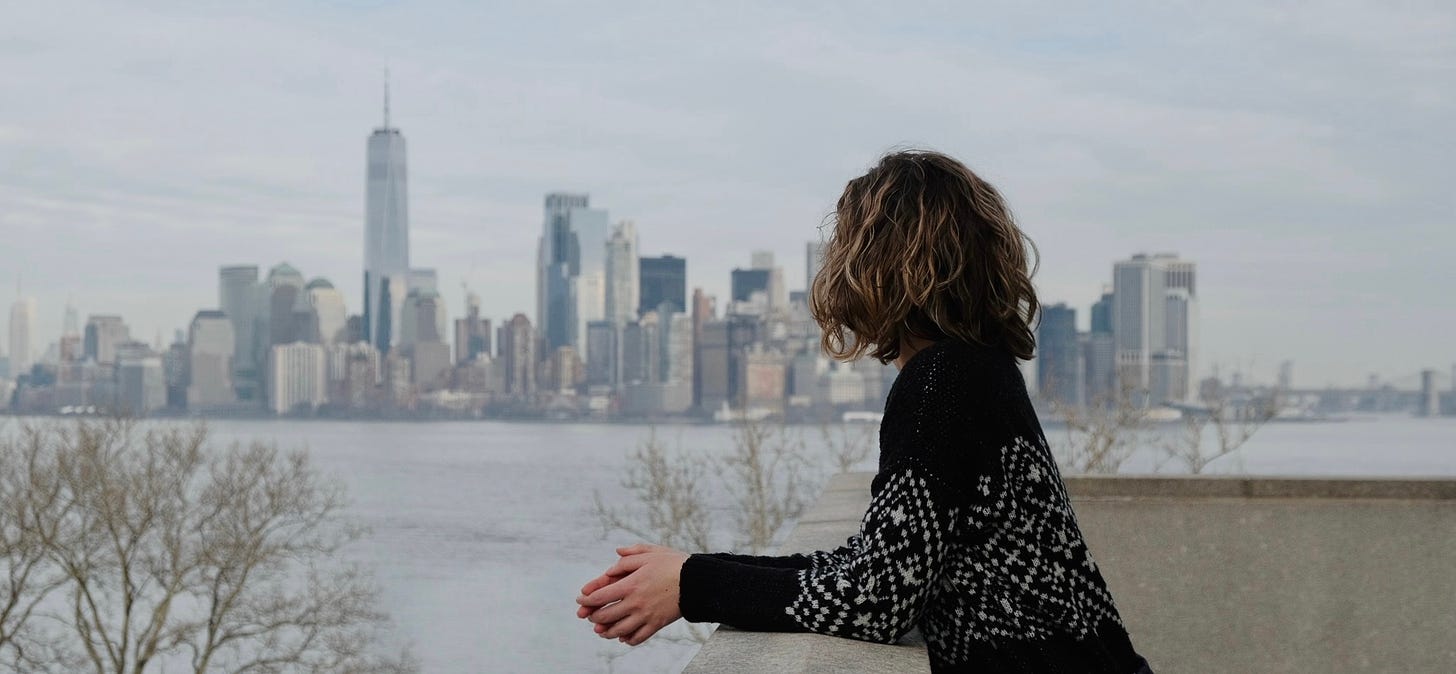 Leah looking away from the camera towards downtown Manhattan in the background. 