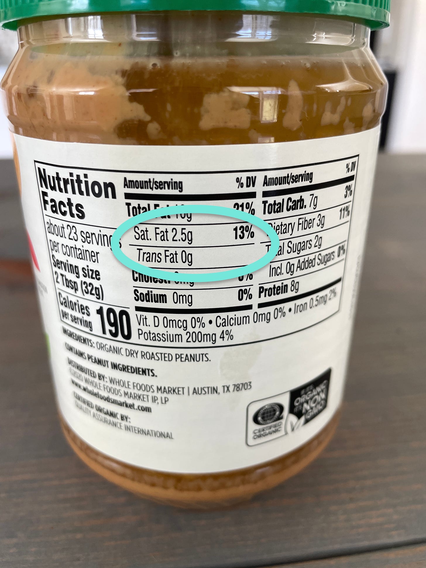 Peanut butter container highlighting saturated fat of thirteen percent daily value and trans fat of zero grams