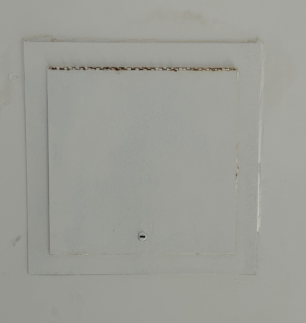 A white metal hatch in the ceiling