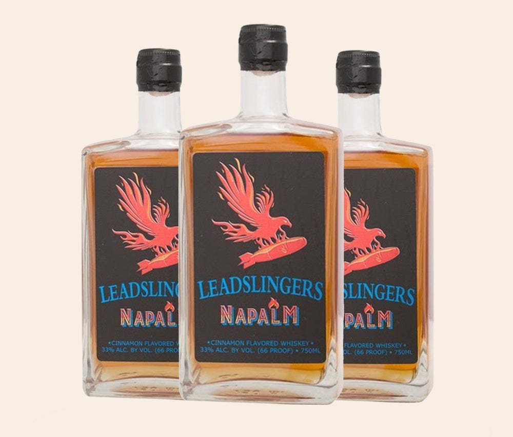 Three bottles of Leadslingers napalm cinnamm flavored whiskey. It has a phoenix with a bomb on it for the logo.