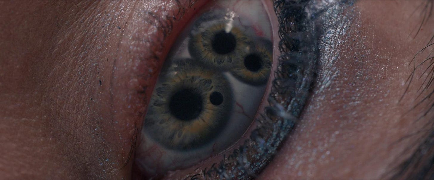 An up-close shot of an eyeball splitting into three different irises and pupils