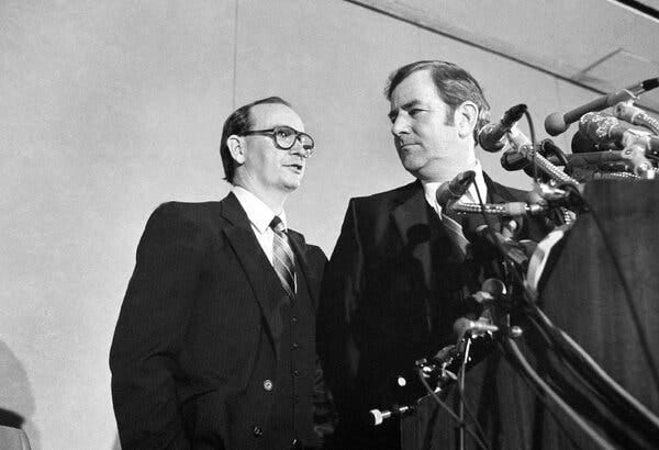 A black-and-white photo of Mr. Wildmon and the Rev. Jerry Falwell at a lectern covered in microphones.