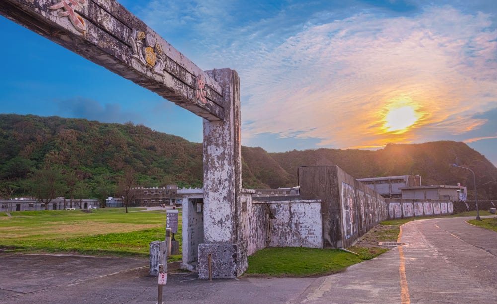 The sun sets over the concrete gate and exterior walls of the New Life Correction Center on Taiwan's Green Island