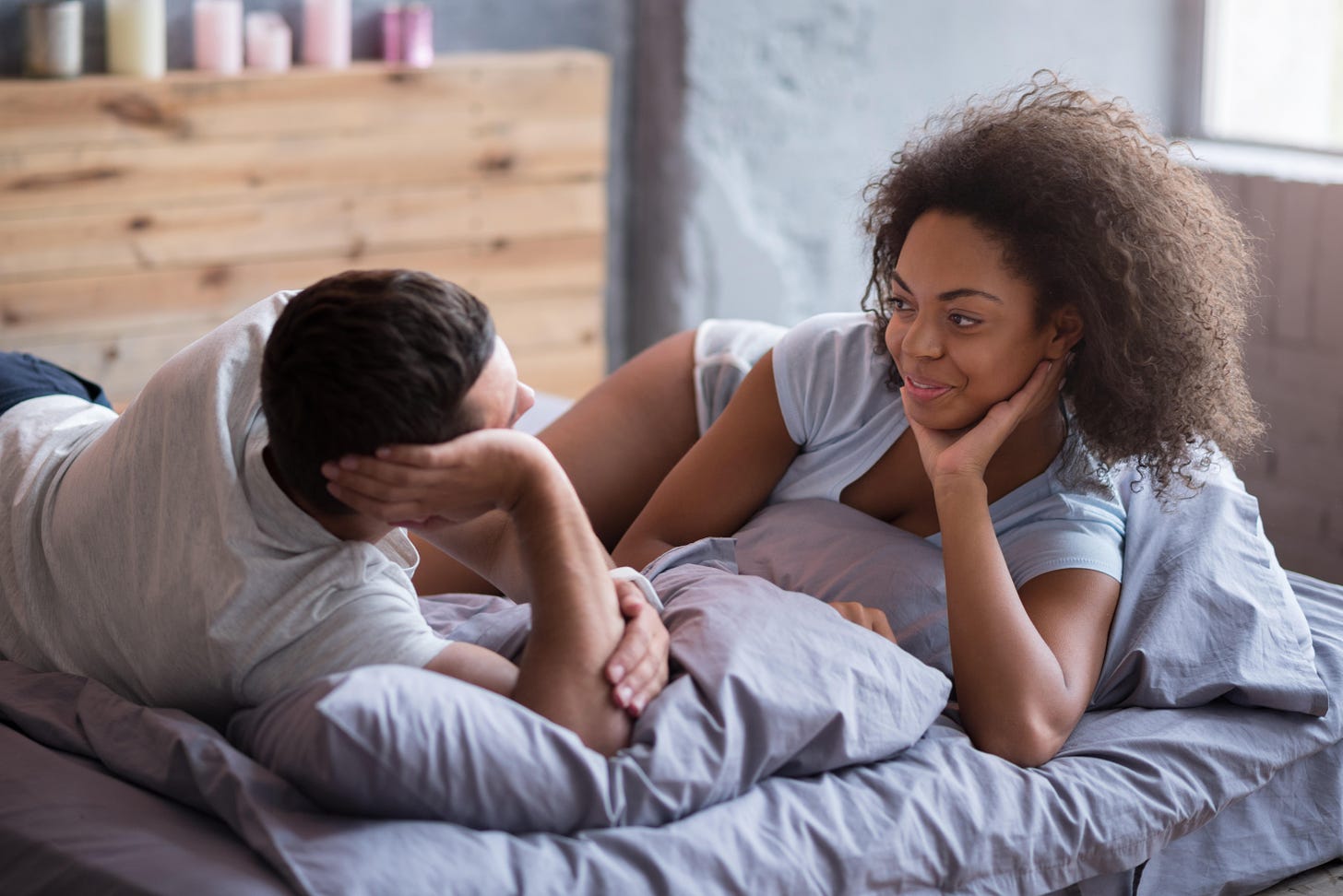 A couple lying in bed chatting