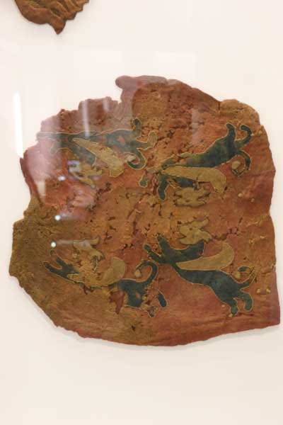 A sample of red fabric with dogs embroidered on