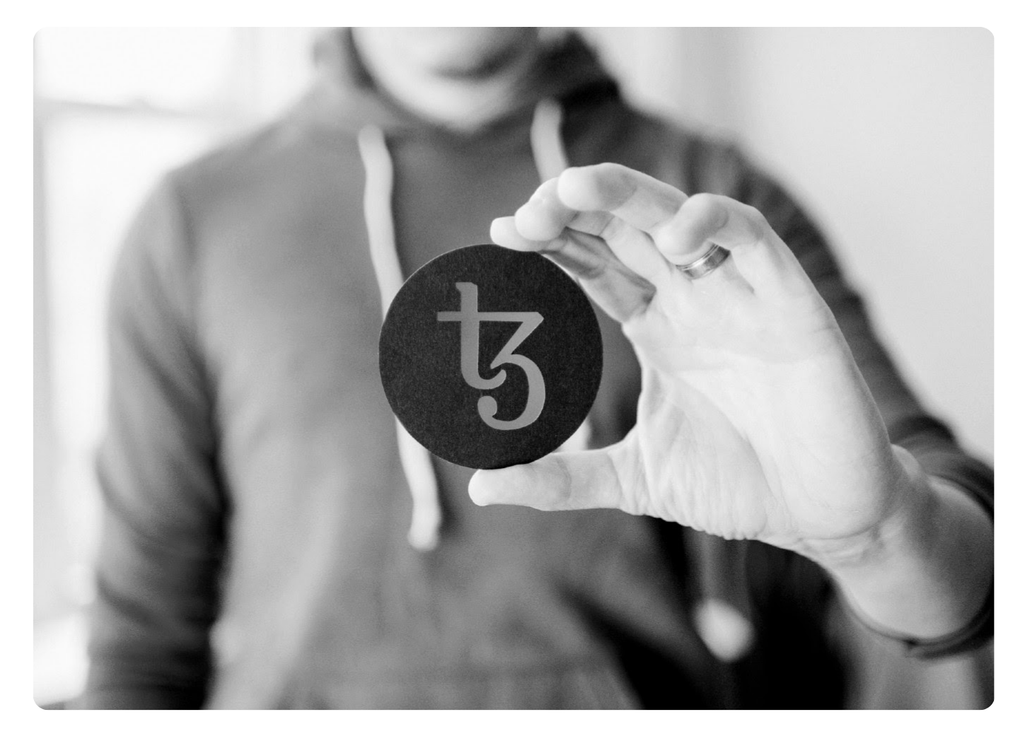 Man holding up a bitcoin token