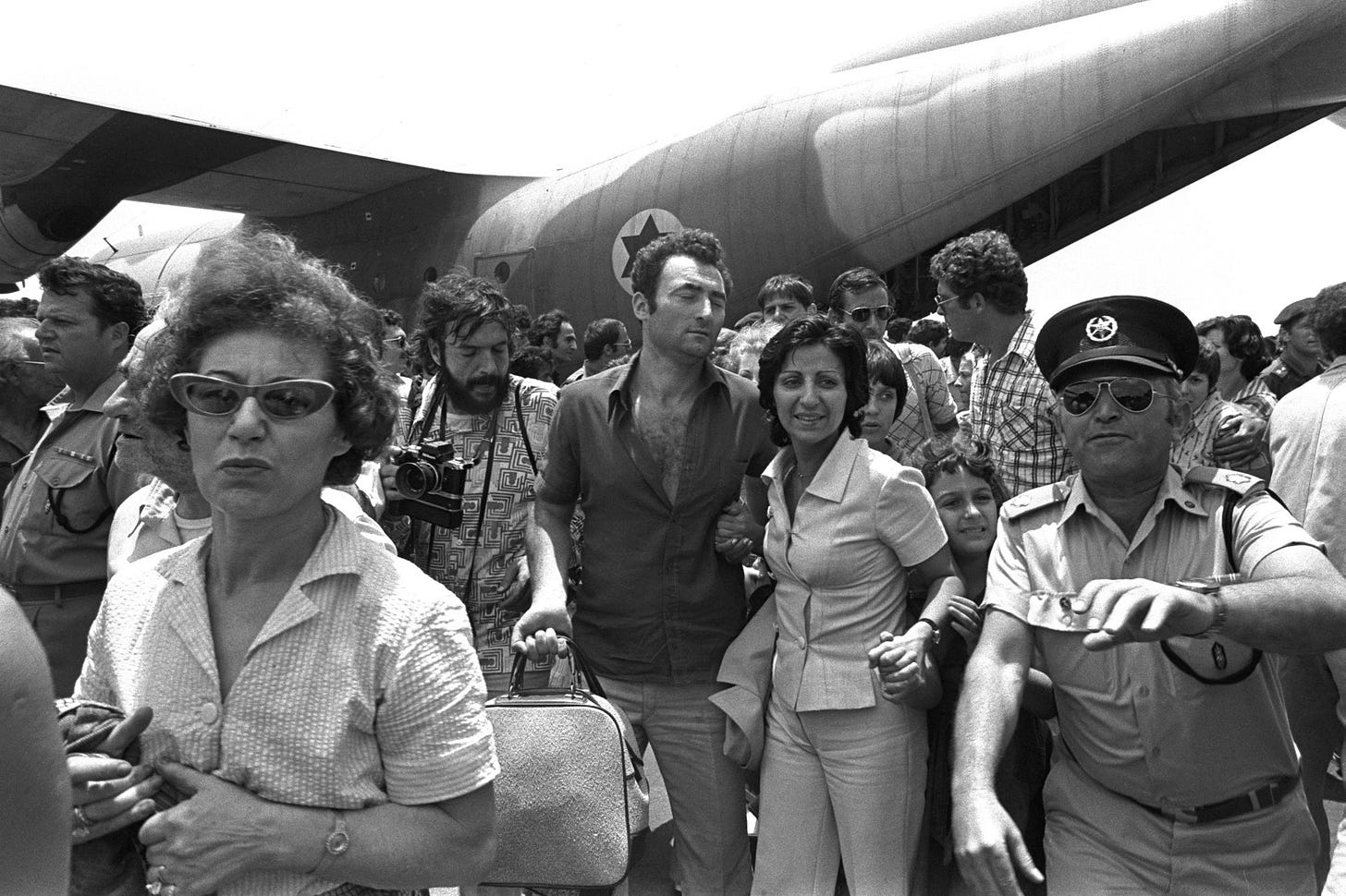 A policeman clears the way for rescued Air France hostages returning from Entebbe Airport on July 4 1976.