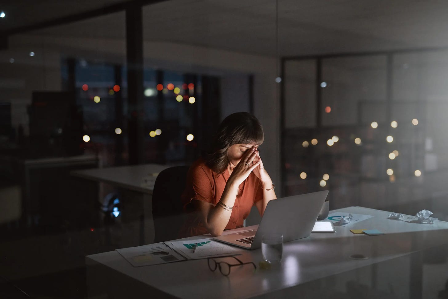 A woman working alone in an office at night