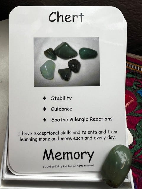 A hand holding a card with a picture of green stones

Description automatically generated