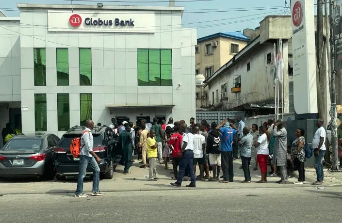 FILE - People queue to withdraw money from a cash machine outside a bank in Lagos, Nigeria, Tuesday, Feb. 7, 2023. Nigeria’s central bank has extended the timeline to swap out its old currency for redesigned notes after the change triggered a cash shortage. On Tuesday, March 14, 2023, both old and redesigned notes were still not available for thousands queued at banks in Nigeria’s capital of Abuja. (AP Photo/Dan Ikpoyi, File)