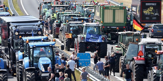 Farmers gather with their vehicles next to a Netherlands/Germany border sign on the A1 Highway near Rijssen during a protest against the Dutch government's nitrogen plans on June 29, 2022.