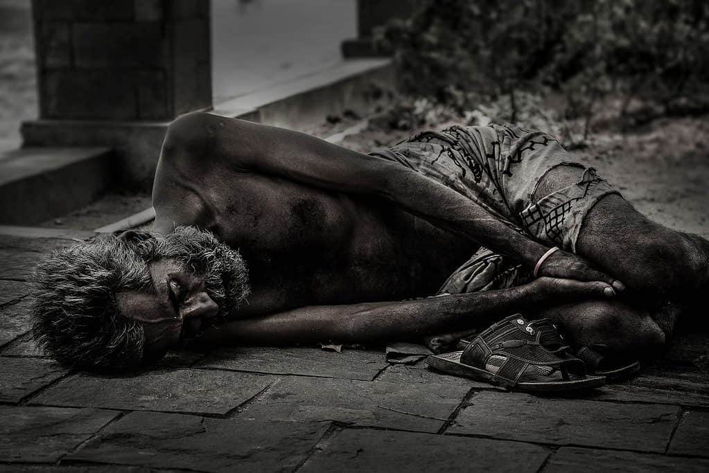 Homeless man in poverty laying on the pavement