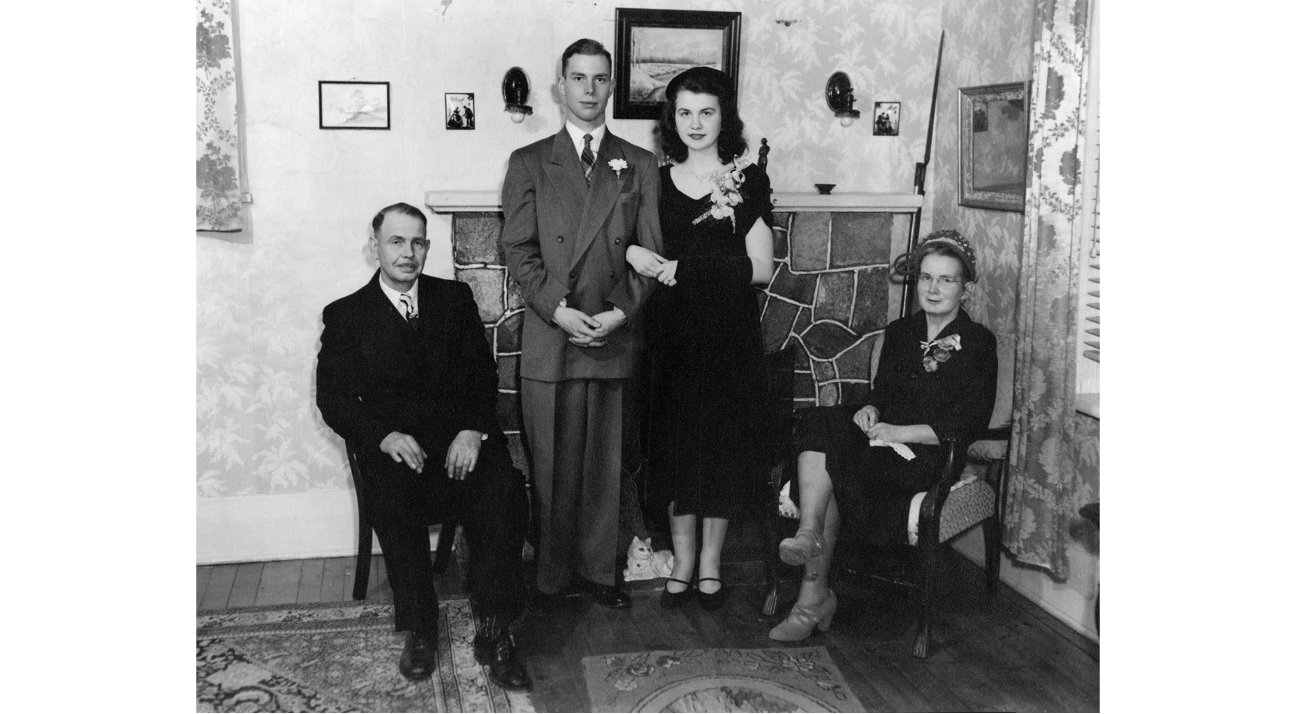 Wedding photo with groom, bride, and bride's parents in a living room, 1951