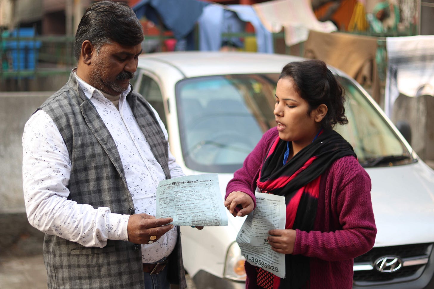 A man and a woman can be seen in the picture holding pamphlets and the woman seems to be educating the man about his rights through the pamphlet A man and a woman can be seen in the picture holding pamphlets and the woman seems to be educating the man about his rights through the pamphlet