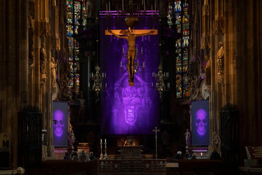 Images of skulls are projected on screens inside a cathedral.