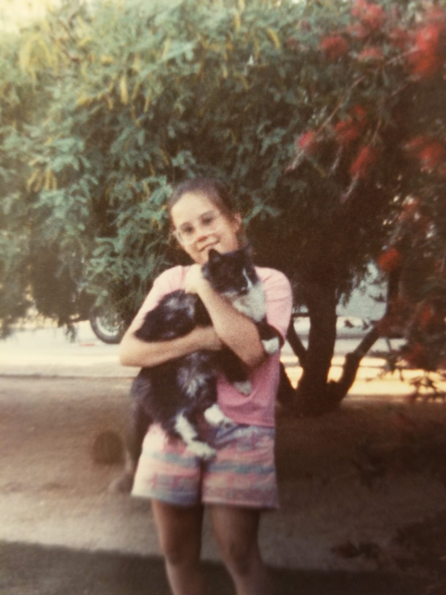 young girl holding a neighborhood cat in Arizona in the 1980s