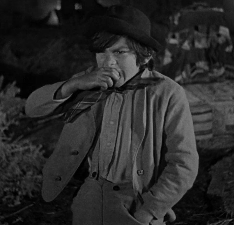 Johnny Fox, child actor, as Jed Wingate in 1923 Western The Covered Wagon. He's taking a big bite from his chewing tobacco anc contemplating a heroic act