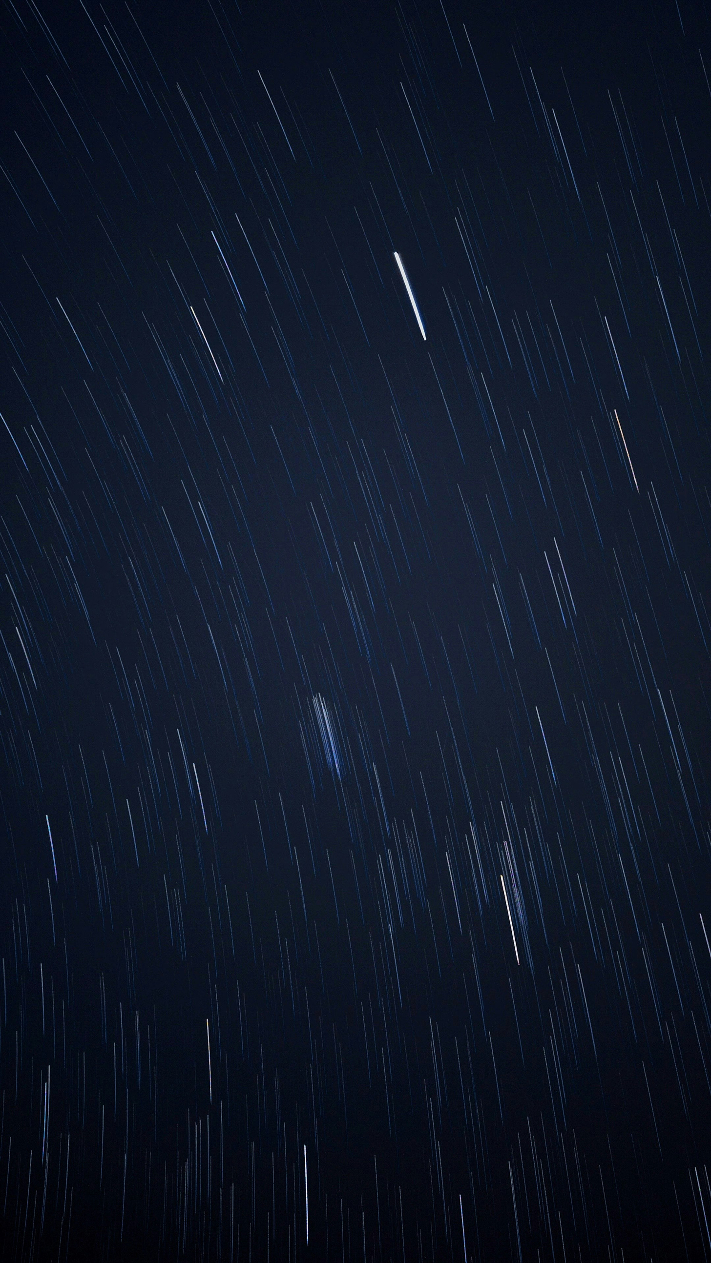 Time-lapse photo of blurry orbiting stars in a night sky