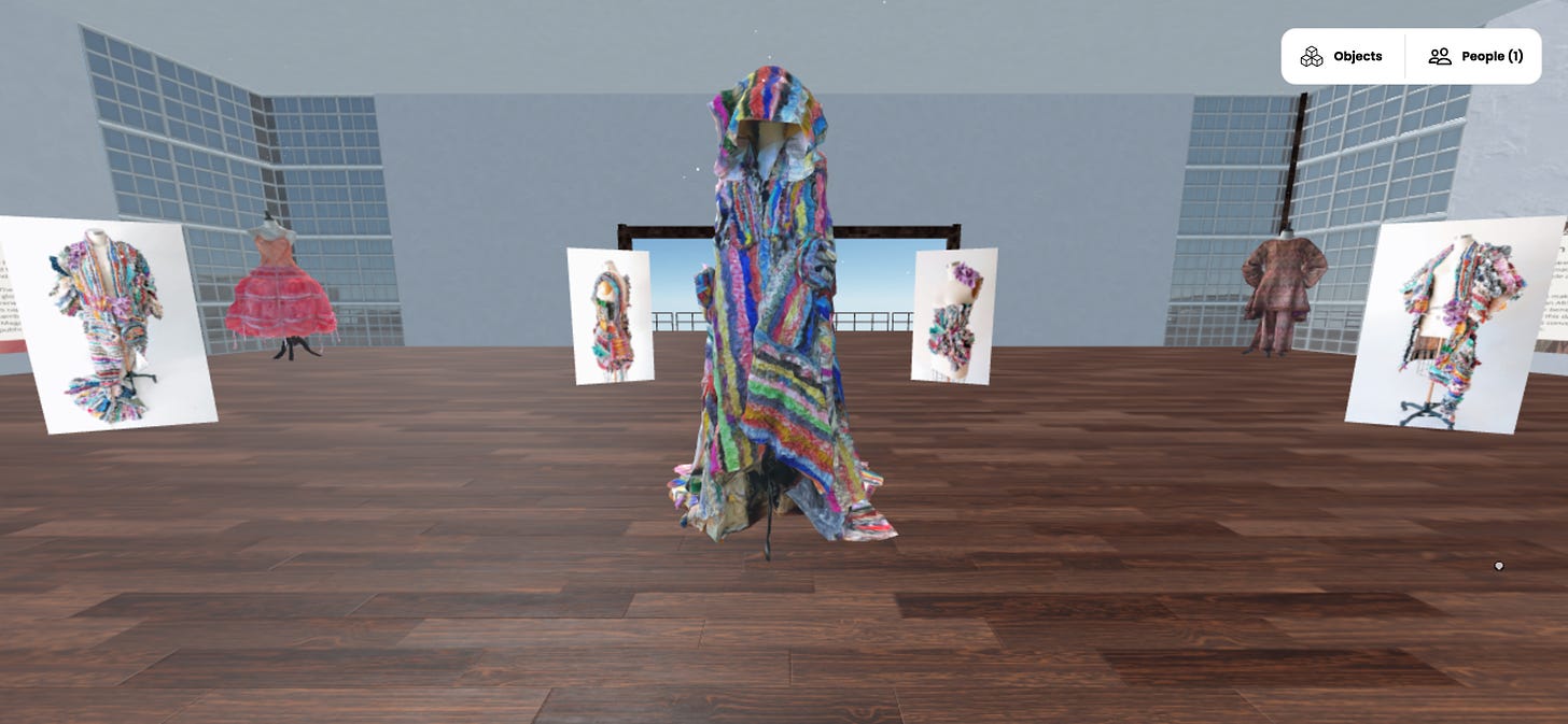 What the scene looks like after it's live. A wide interior gallery space with tall celling and hardwood floor, filled with three 3D dress form scans and 4 flat images floating in vertical orientation.