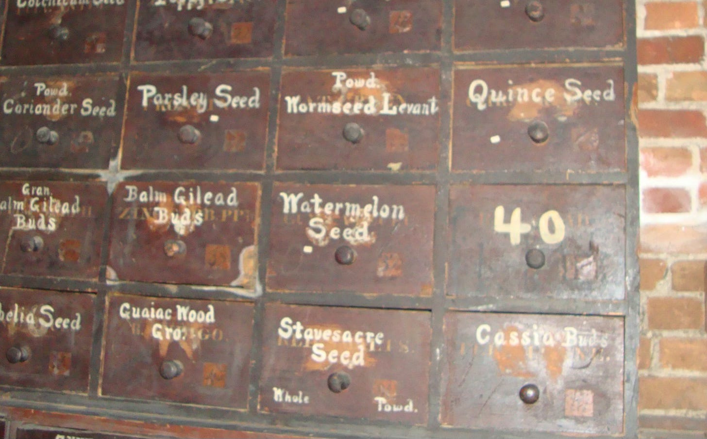 Old wooden pharmacy drawers including one labelled Quince seeds