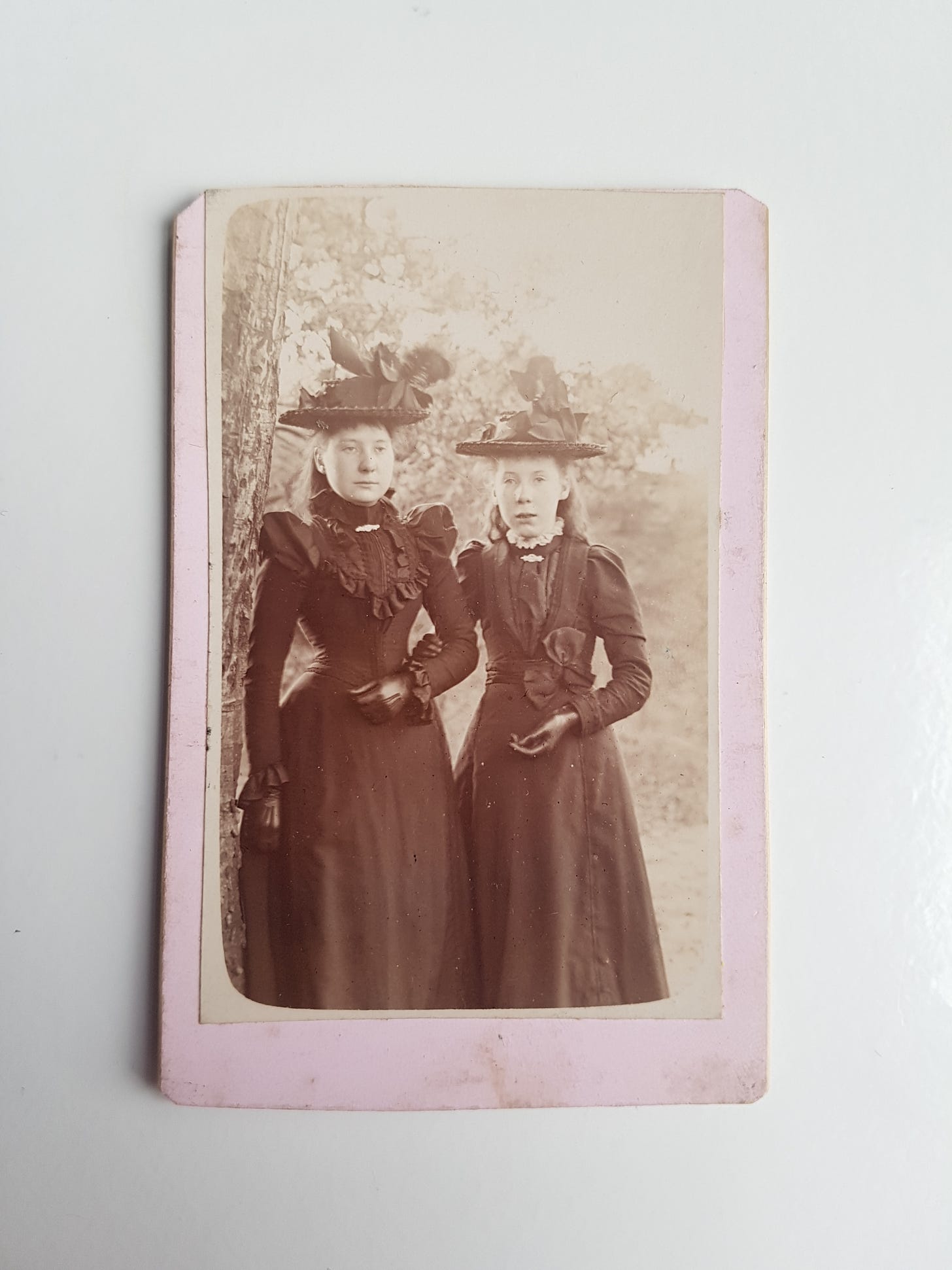 Two young ladies from Fife wearing late Victorian fashion. Photo is placed on a white desk