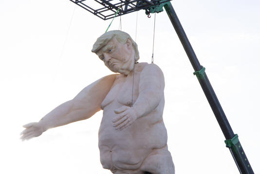 A 43-foot-tall (13 meters) naked statue resembling former US President and Republican presidential candidate Donald Trump is displayed in a fenced-in lot near Interstate 15 north of Las Vegas, Nevada, September 28, 2024. Made of foam over rebar and weighing approximately 6,000 pounds (2722 kilos), the gigantic display also appeared at a park in Pennsylvania as part of the "Crooked and Obscene Tour."