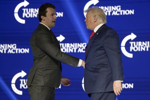 FILE - Former President Donald Trump, right, shakes hands with Turning Point CEO Charlie Kirk before speaking during the Turning Point USA Student Action Summit, July 23, 2022, in Tampa, Fla. The nonprofit rocketed to prominence by latching on to Trump’s 2016 campaign and has raised roughly a quarter-billion dollars since, much of it spent cultivating conservative influencers and hosting glitzy events. The organization also enriched Kirk and his allies, according to an Associated Press review of public records. (AP Photo/Phelan M. Ebenhack, File)