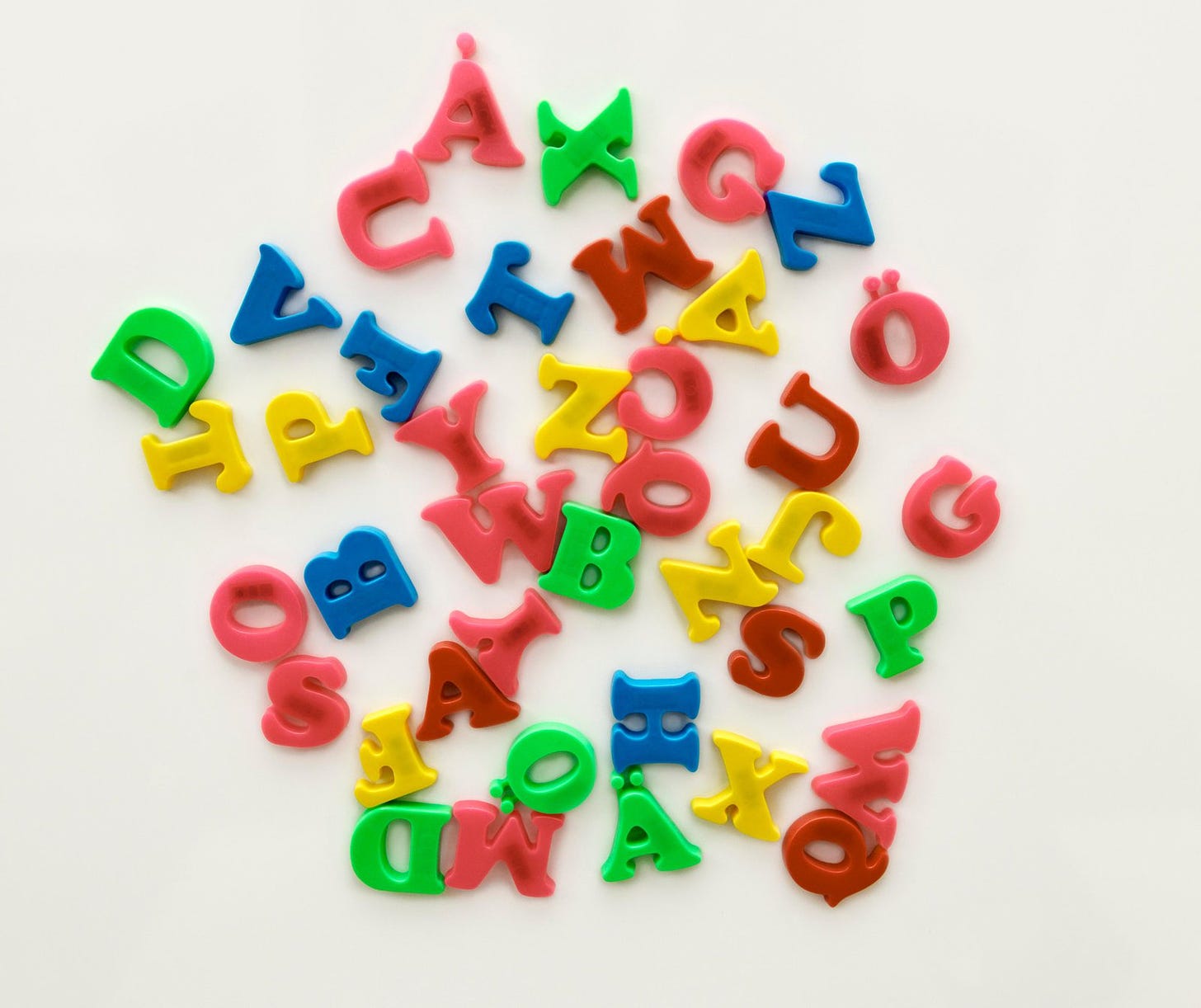 Colorful letter magnets in a jumble on a white background