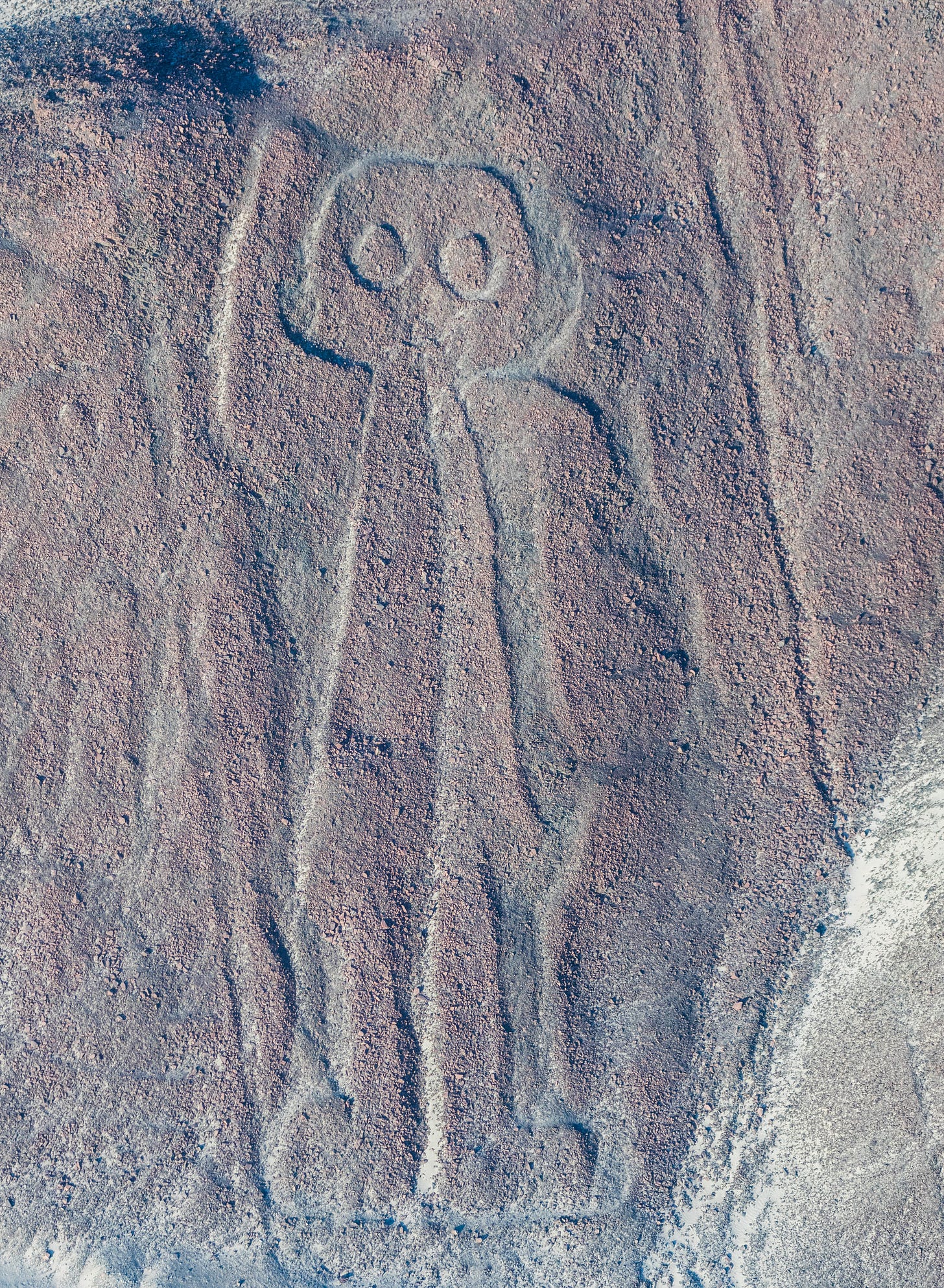Aerial photo of one of the Nazca Geoglyphs, which looks like a simple drawing of a human waving.