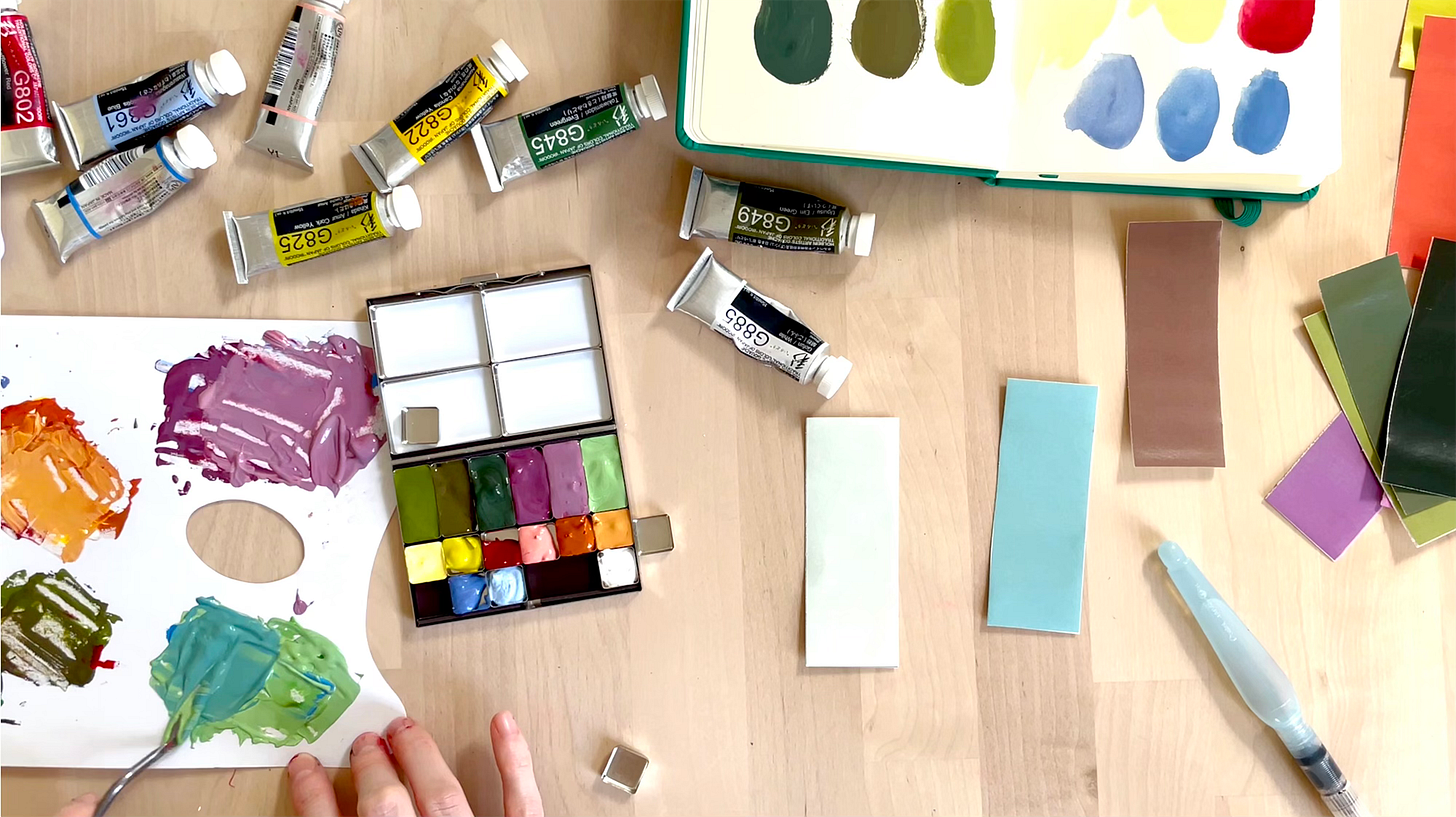 A table with paints and a colour palette