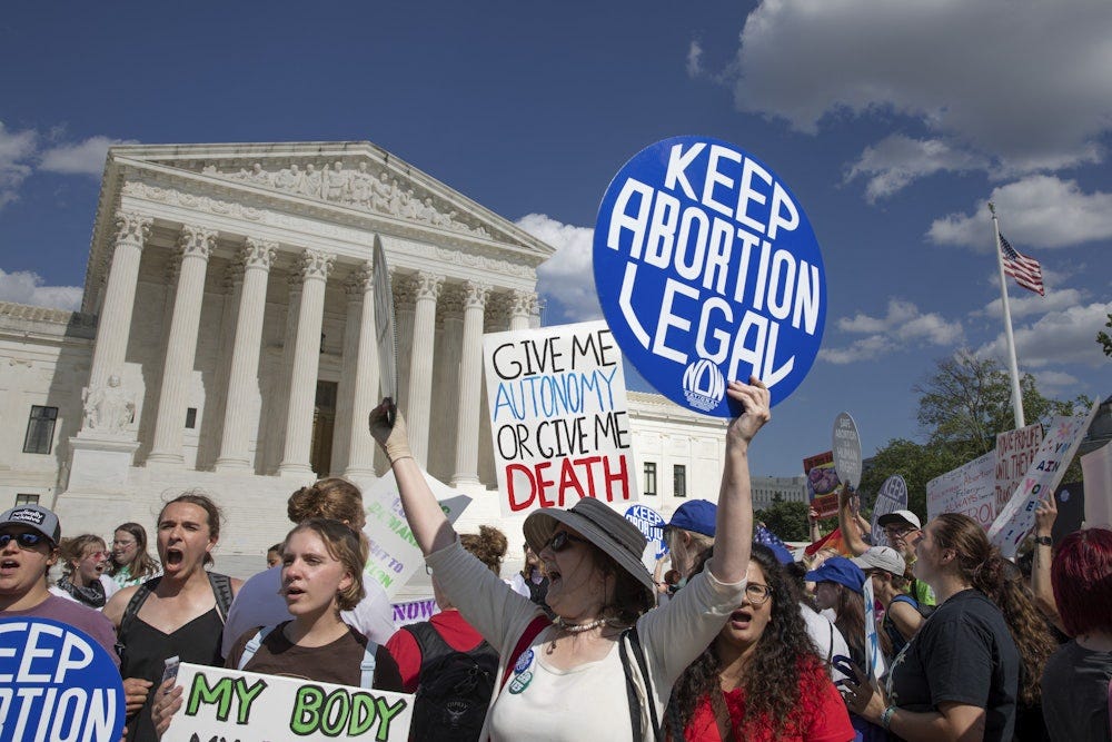 Women hold signs during an abortion rights demonstration in front of the U.S. Supreme Court in Washington, D.C.