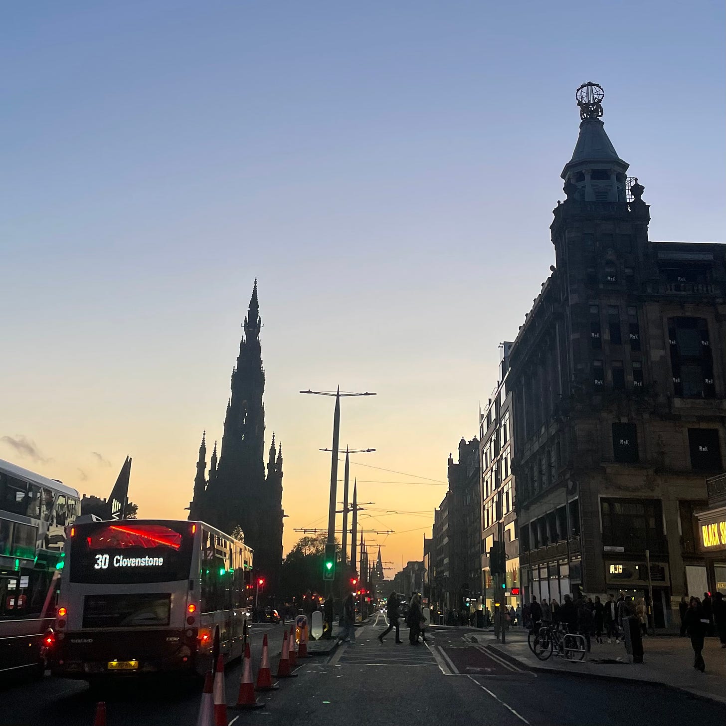 A clear sunset sky over Edinburgh’s skyline, with buses in the foreground. 