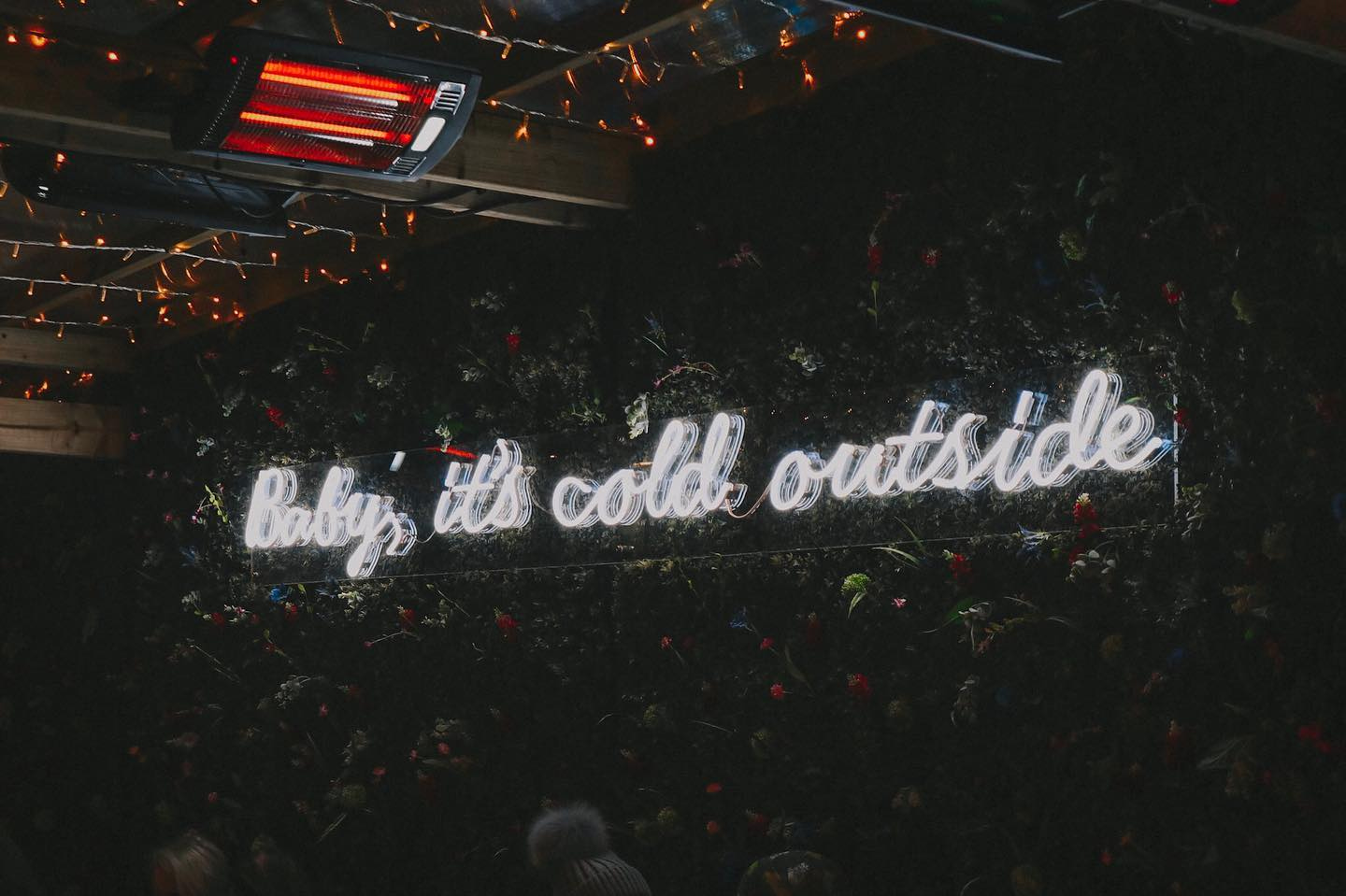 A neon sign reading ‘baby, it’s cold outside’ at a Christmas market in London.