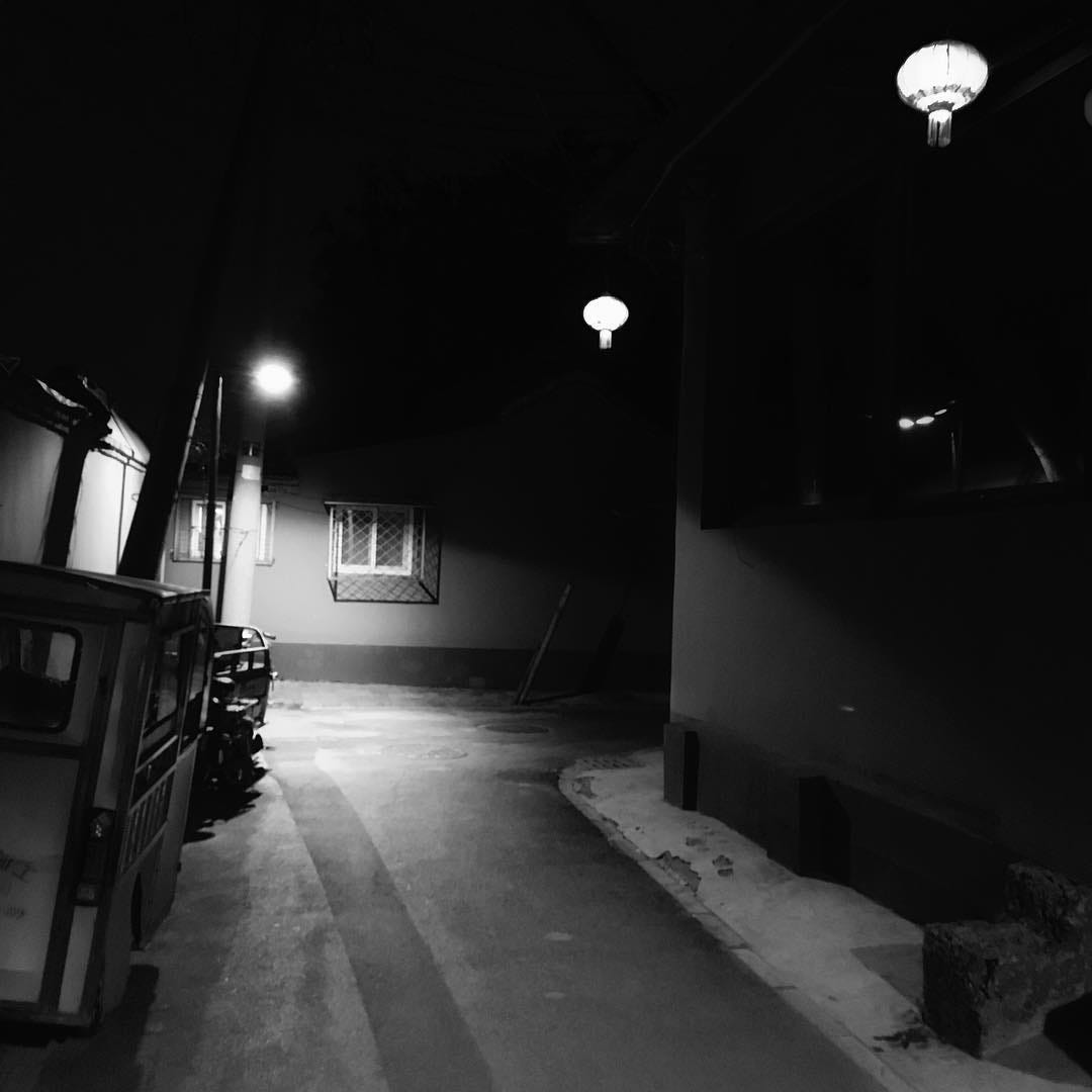 Beijing hutong at night, with a thin layer of snow covering the pavement.