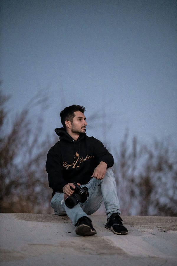 Man sitting down with camera in hand.