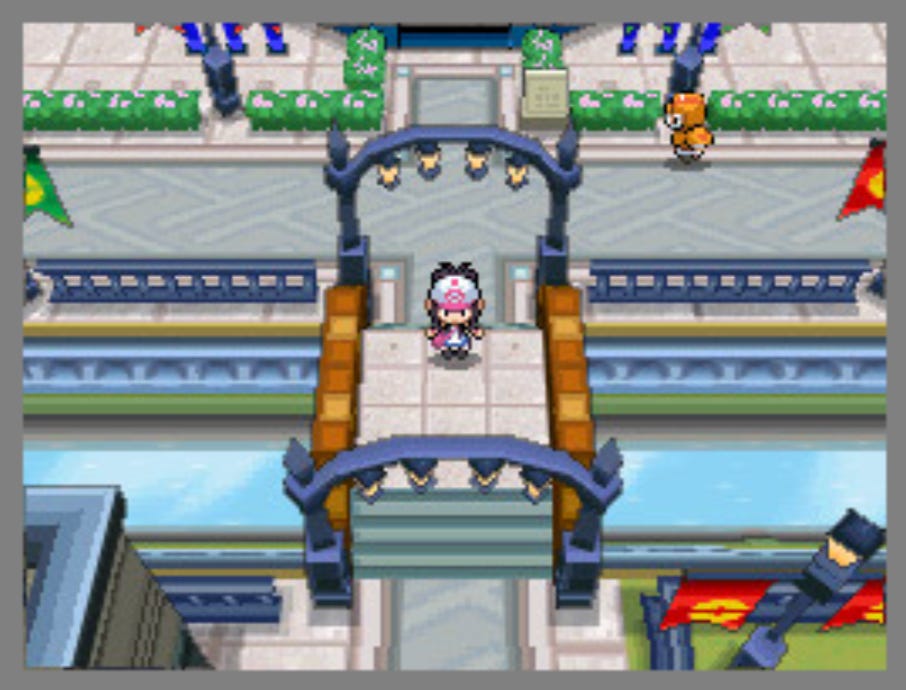 Video game screenshot showing an overhead view of a person standing on a bridge in a town. 