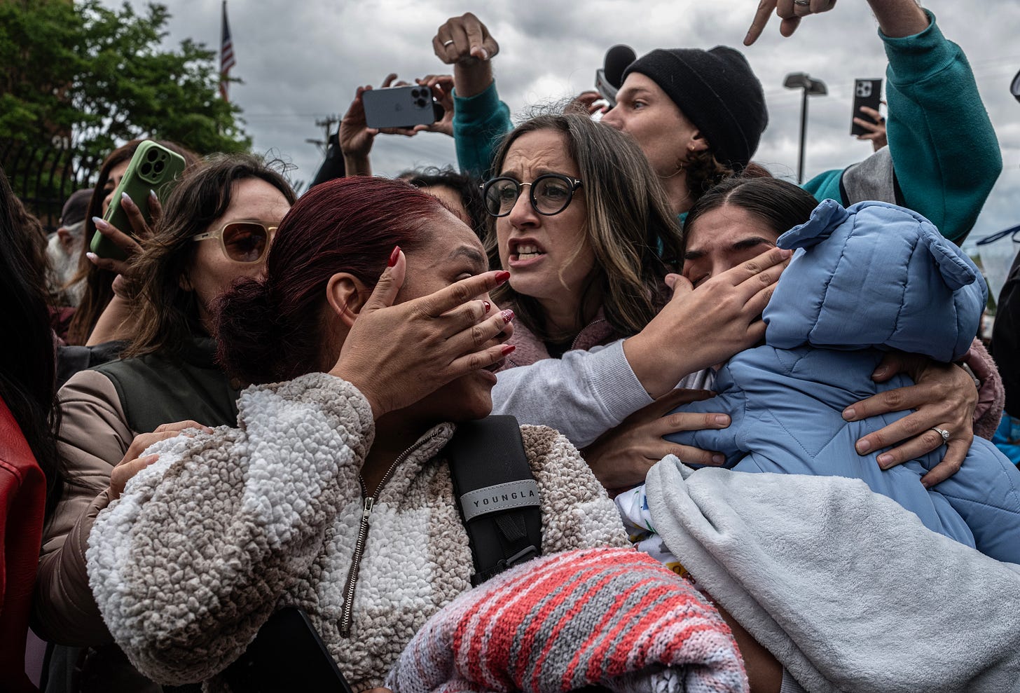 From left, Betzbet Rojas, 25, and Unimare Estrada, 24, protest the detention of their husbands, thought to be on Immigration and Customs Enforcement buses. Sarah Shoop Neumann, center, joins the protest. (Photo: John Partipilo/Tennessee Lookout)