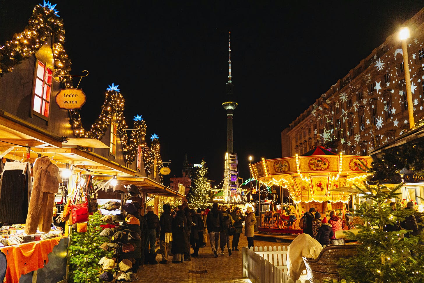 Photo of the Christmas Market at Alexanderplatz in Berlin, Germany at night with a view of the TV tower in the background.