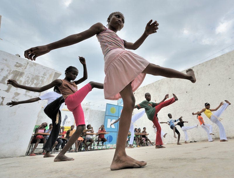 Children practice capoeira on January 24, 2010, in a camp for homeless families in the Belair section of Port-au-Prince. The program, run by Viva Rio, a Brazilian nongovernmental organization, is designed to help children affected by the quake recover their emotional well-being. Under "informed consent" rules that require prior approval, the photographer would have had to stop the girls from playing, go with them to find their parents, explain the intricacies of "informed consent" and usage, get their signatures, then return to the community center to photograph the activity. That's a process that's allegedly designed to assure that the children are not depicted in an undignified manner. Photo by Paul Jeffrey. Children practice capoeira on January 24, 2010, in a camp for homeless families in the Belair section of Port-au-Prince. The program, run by Viva Rio, a Brazilian nongovernmental organization, is designed to help children affected by the quake recover their emotional well-being. Under "informed consent" rules that require prior approval, the photographer would have had to stop the girls from playing, go with them to find their parents, explain the intricacies of "informed consent" and usage, get their signatures, then return to the community center to photograph the activity. That's a process that's allegedly designed to assure that the children are not depicted in an undignified manner. Photo by Paul Jeffrey.