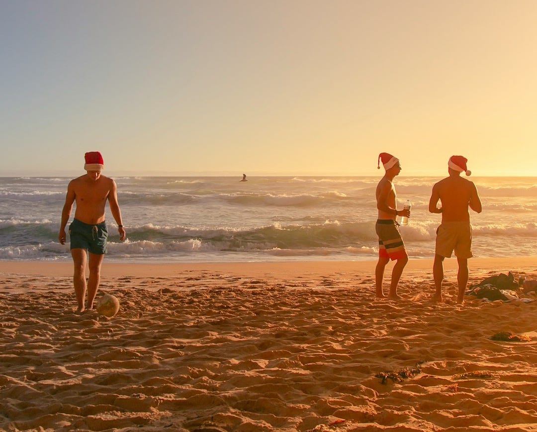 a group of people standing on top of a sandy beach