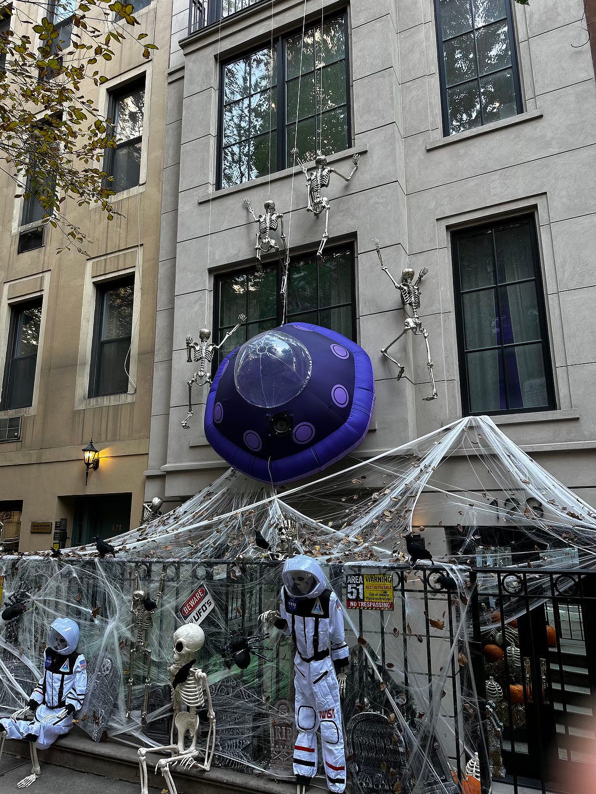 A vertical shot of the Area 51 decorations in NYC. The skeletons have gained decent height scaling the wall of the building.