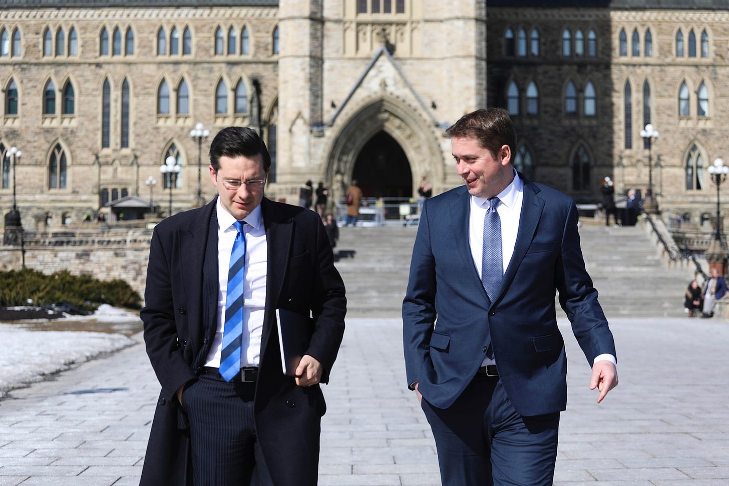 Pierre Poilievre walks with Andrew Scheer outside the Parliament buildings in Ottawa.