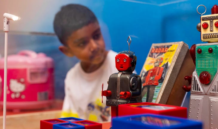 A young boy looking at a display of robot toys