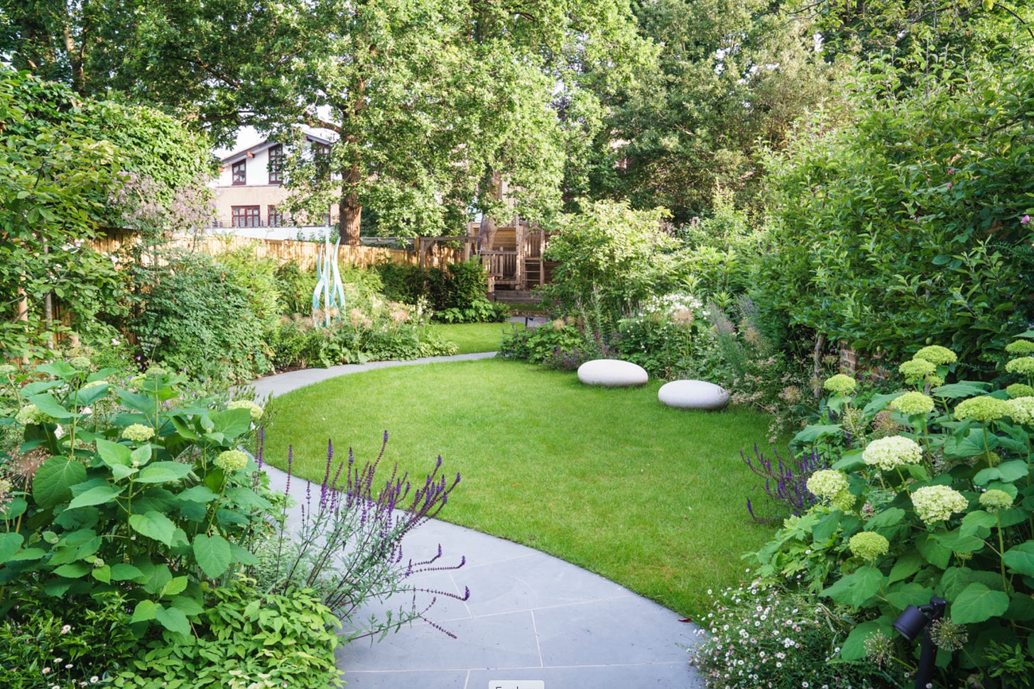 A London garden with a path, lawn and climbing frame