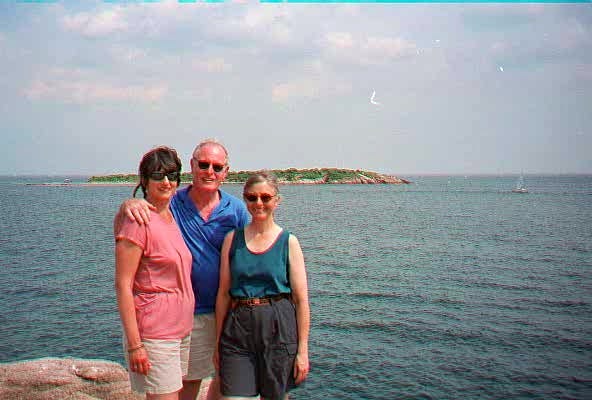 A group of people standing on a rock by the water

Description automatically generated