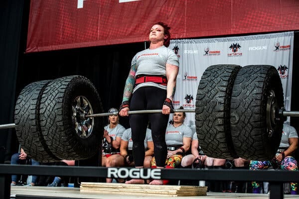 Rebecca Lorch lifts a weight that includes two truck tires on either end.