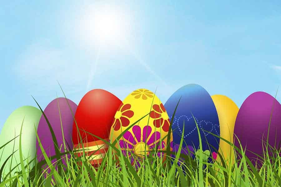 colourful easter eggs on grass against a blue sky