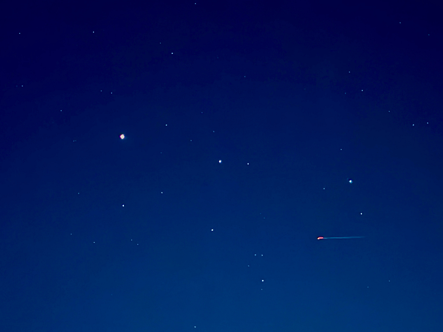 Mars next to Castor & Pollux and other stars of Gemini, with plane flying across the frame